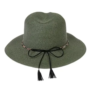 Detail of olive green straw Panama hat with golden chain and black bow decoration