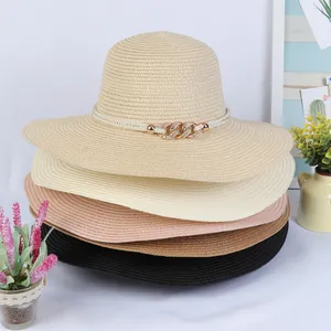 Close-up of colorful stacked straw hats featuring elegant gold metal chain buckle details