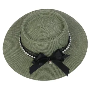 Detailed texture of green straw hat with black lace ribbon and pearl bow decoration