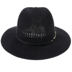 Detail of black woven fedora hat with elegant gold buckle and decorative band texture