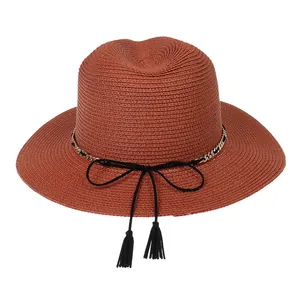 Detail of hand-woven texture on wide-brim Panama hat with elegant gold chain trim