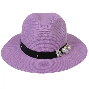 Détail du chapeau Fedora violet avec ornements en perles et fleurs sur ruban noir