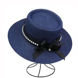 Detailed close-up of navy boater hat with white pearls and black satin bow decoration