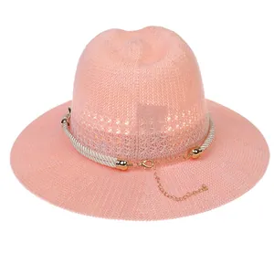 Close-up of pink breathable straw hat with textured weave and white twisted rope band