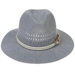 Detail of grey hollow straw fedora with cream rope and rose gold chain link accent