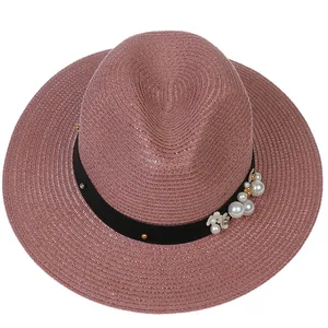 Détail du chapeau Panama rose avec texture tressée, perles et ruban floral