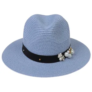 Détail de la texture du chapeau Panama bleu clair avec perles et ruban à fleurs