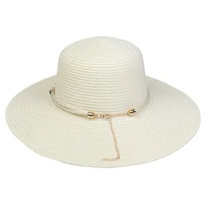 Detail of cream straw hat featuring a wide brim and decorative golden chain band