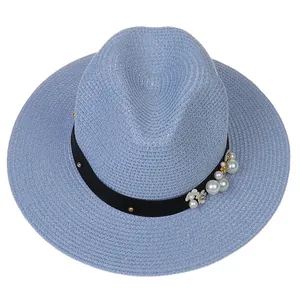 Détail du chapeau Panama bleu clair avec perles, fleurs et ruban noir pour l'élégance