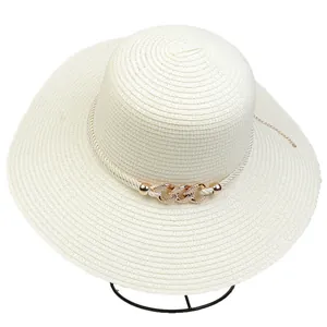 Detail of white wide-brim straw hat with rose gold chain and elegant woven rope band