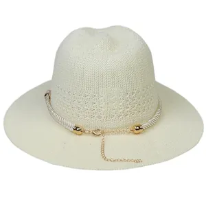 Detail of cream straw fedora with decorative white braided rope and gold metal accents