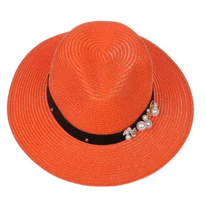 Vue de dessus du chapeau Panama orange vif avec ruban noir, clous et détails de perles