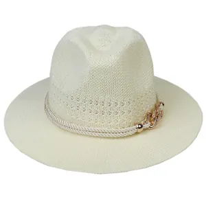 Detail of hollow woven straw hat with rope band and gold chain accent for summer beach