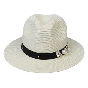 Détail d'un chapeau Panama crème avec ruban noir, perles et accents floraux élégants