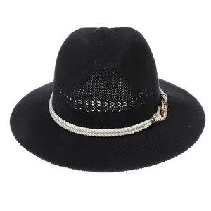 Detailed view of black woven straw hat featuring a cream rope band and metallic buckle