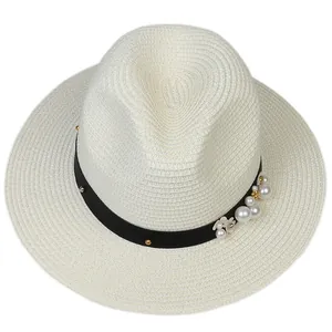 Détails de chapeau Panama tissé avec décorations de perles et de fleurs sur ruban noir