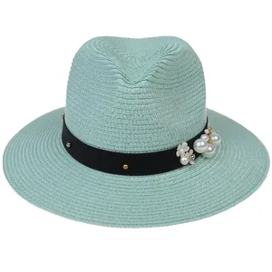 Détail du chapeau de paille vert menthe avec ruban clouté et accents floraux perles