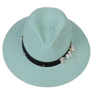 Détail du chapeau Panama vert menthe avec ruban noir, perles et accents floraux