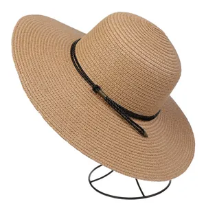 Close-up of the light brown straw sun hat with black woven cord and metal buckle adjustment