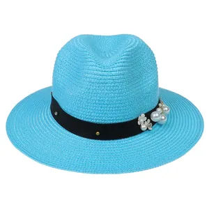 Détail du chapeau Panama bleu clair avec ruban noir, perles et décorations florales