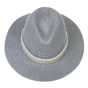 Overhead detail of grey woven straw fedora featuring pearl and gold chain decoration