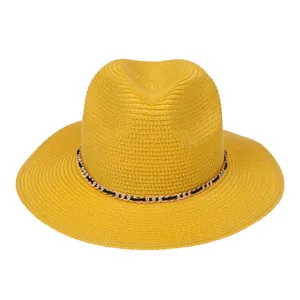 Detail of bright yellow Panama straw hat featuring a gold chain and woven texture