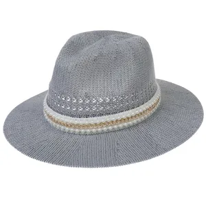 Detail of grey woven straw fedora hat featuring a white pearl and gold chain band
