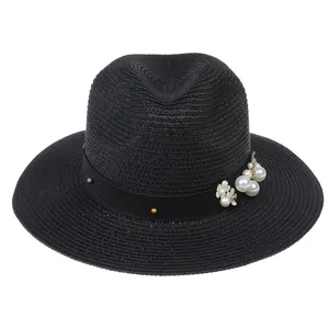 Détail d'un chapeau de paille Panama noir avec perles élégantes et fleurs argentées