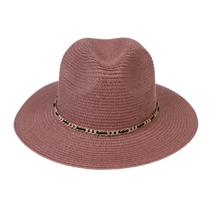 Detailed weave of dusty pink straw hat with a decorative gold chain and leather band
