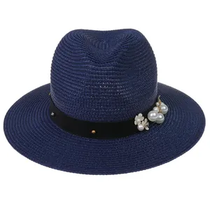 Détail d'un chapeau Panama bleu marine avec ruban orné de perles et de petites fleurs