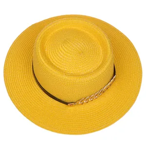 Top view of yellow straw boater hat with black ribbon and gold leaf chain decoration