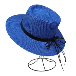 Detail von blauem Strohhut mit schwarzem Band und eleganter Webstruktur auf Ständer