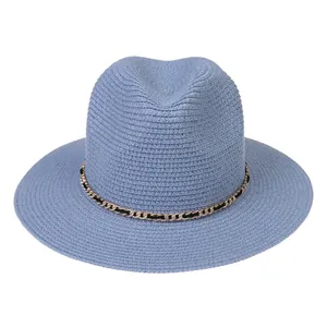 Detail view of sky blue straw panama hat with gold chain and black ribbon trim