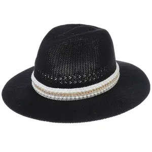 Detailed view of black woven sun hat featuring elegant white ribbon and faux pearl chain