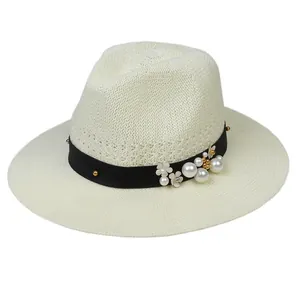 Elegant beige woven straw hat with pearl and floral ribbon decoration for summer seaside