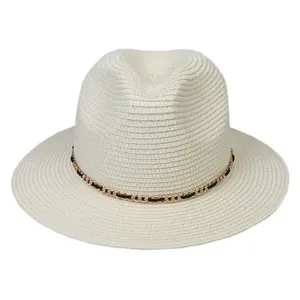 Detail of Panama straw hat featuring a stylish black and gold metallic chain band