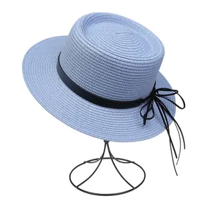 Detailansicht hellblauer Strohhut mit schwarzer Schleife und elegantem Band auf einem Halter