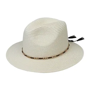 Close-up of woven straw fedora featuring a decorative gold chain and black tassel