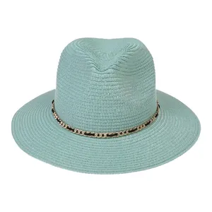 Detailed texture of mint green straw fedora hat featuring a gold and black chain band