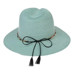 Detail of mint green woven panama hat showing the gold chain and black tassel bow