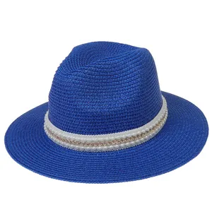 Détail du chapeau Panama bleu royal avec ruban de perles et chaîne dorée élégante