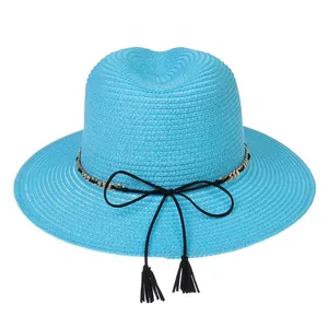 Close-up of bright blue straw hat with a gold chain trim and black tassel bow detail