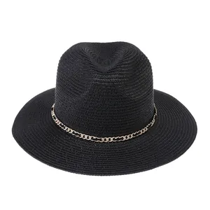 Close-up of black woven Panama hat featuring a stylish gold chain trim and wide brim