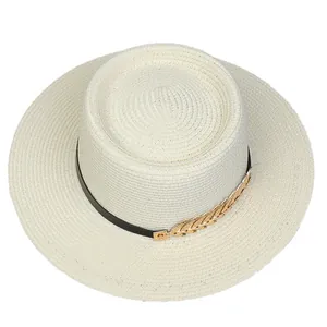 Detail of off-white boater hat with black ribbon and gold feather buckle decoration