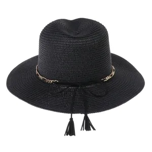 Detailed texture of black woven Panama sun hat with gold chain and dual tassels decoration