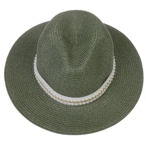 Vue de dessus d'un chapeau Panama vert foncé avec ruban blanc, perles et chaîne dorée
