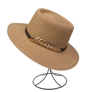 Detail of straw hat with black band and gold feather ornament on metal stand