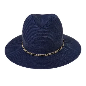Close-up of a navy blue paper straw fedora hat featuring a gold and black chain band