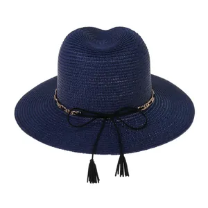 Detail of dark blue straw Panama hat with elegant gold chain and black tassel ribbon