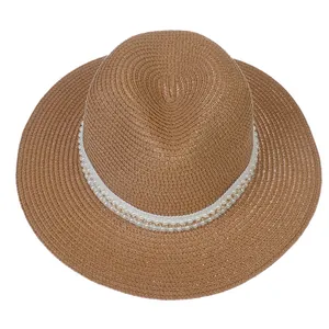 Détail d'un chapeau Panama marron avec garniture en perles et texture tissée fine